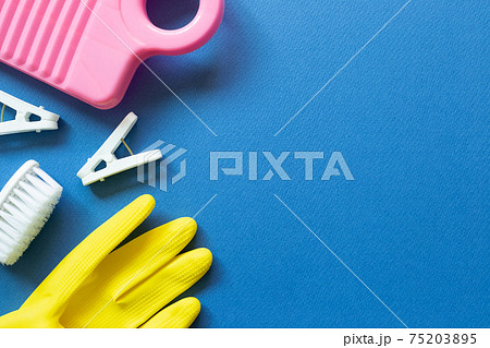 Washboard, clothespins, brush, rubber gloves on blue background. Laundry and cleaning concept. top view, copy space Washboard, clothespins, brush, rubber gloves on blue background. Laundry and cleaning concept. top view, copy space 75203895