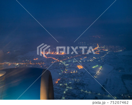 view of airplane turbine over snow covered village 75207462