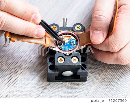 view of watchmaker replacing battery in watch 75207560