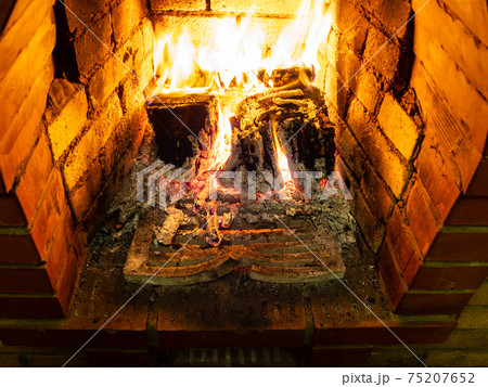 grate and burning firewood in fireplace 75207652