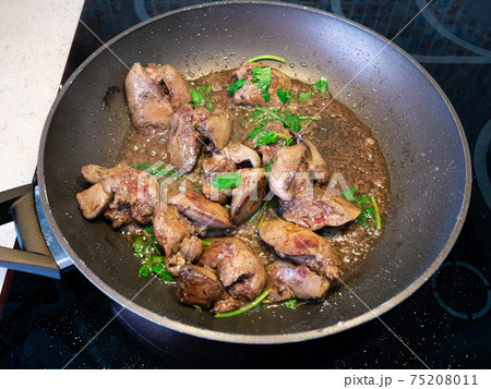 chicken liver with herbs are frying in pan 75208011