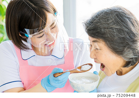 手袋とフェイスガードをして食事介助 手袋とフェイスガードをして食事介助 75209448