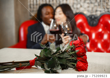 Wedding ring with a diamond on table with flowers in a cafe Wedding ring with a diamond on table with flowers in a cafe 75209923