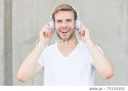 Wireless Earpiece. Handsome guy wear headphones grey  75210102