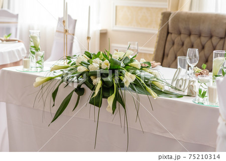 Beautiful decoration of the wedding holiday with flowers and greenery with florist decoration 75210314