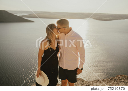 man and woman in love walk on a mountain above a large lake sea 75210870