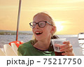 Young blonde girl in glasses have fun discovering islands on summer coastal cruise. Travel adventure, yachting with kids on family vacation. 75217750