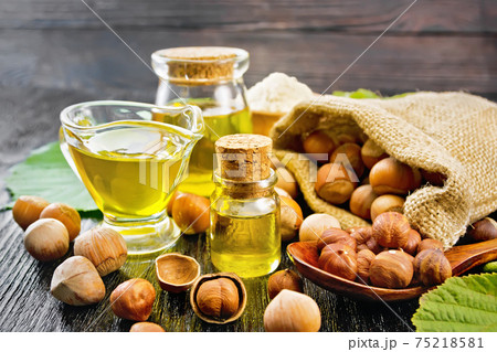 Oil hazelnut in vial on wooden board 75218581