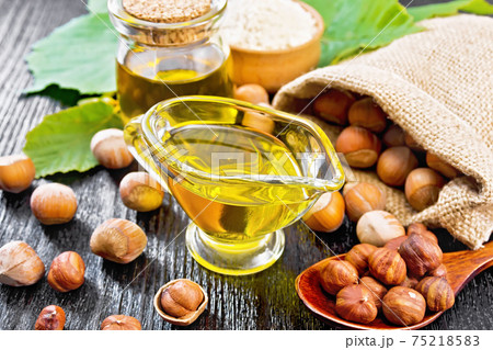 Oil hazelnut in sauceboat on dark board 75218583