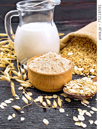 Flour oat in bowl with oatmeal on board Flour oat in bowl with oatmeal on board 75218591