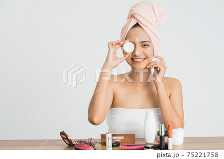 Young asian woman applying cosmetic cream on her face Young asian woman applying cosmetic cream on her face 75221758