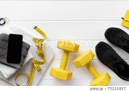 Flat lay top view sport equipments, sneakers and smartphone on wooden background Flat lay top view sport equipments, sneakers and smartphone on wooden background 75221957