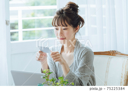 バソコンを使ってキャッシュレス決済する若い女性 75225384