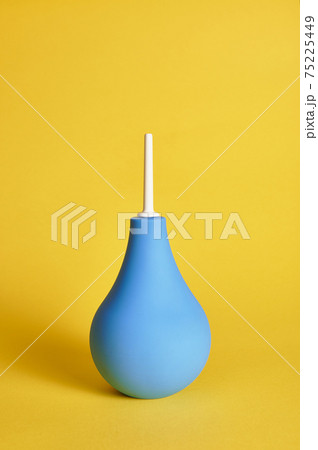 Medical rubber enema on yellow background with copy space. Shot with light shadow. 75225449