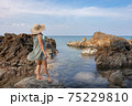 Beautiful woman walking on rock over sea 75229810