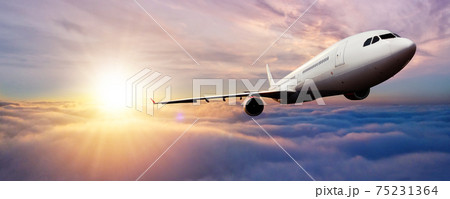 Passenger jetplane flying above clouds in sunset 75231364