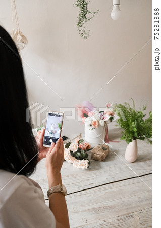 girl removes flowers on the phone. Flowers through the lens girl removes flowers on the phone. Flowers through the lens 75231388