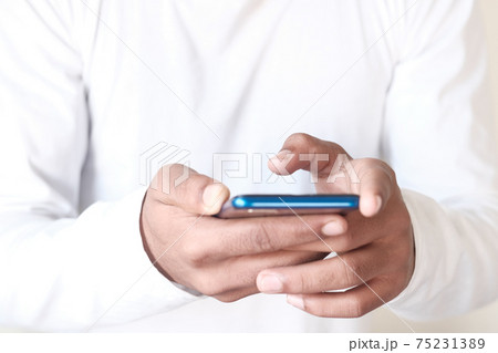 Close up of young man hand using smart phone. Close up of young man hand using smart phone. 75231389