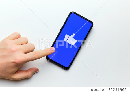 Person hand wants to press the thumb up for evaluation on the Internet using a smartphone 75231962