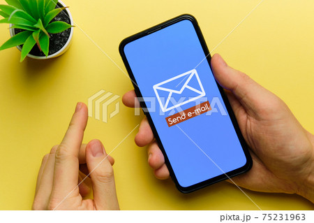 Person sends an email using a smartphone in his hands 75231963