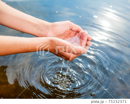 Holding water in cupped hands 75232371