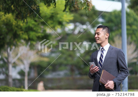 スーツ　時計　会社員　新入社員　働く人　ビジネス　屋外　若い男性　ビル　コロナ　営業　コピースペース 75234798
