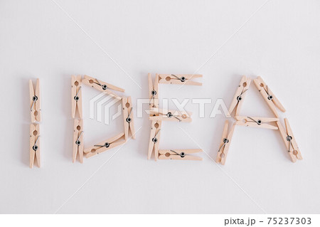 Wooden clothespins on a white background with the inscription the word idea. View from above Wooden clothespins on a white background with the inscription the word idea. View from above 75237303