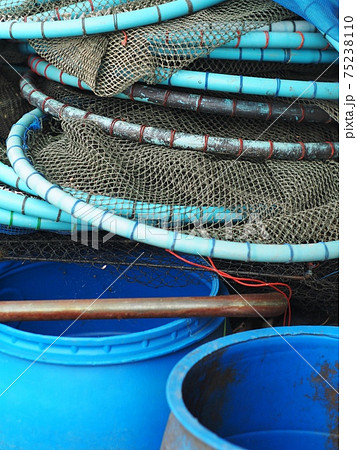 fishing fish net catcher made of dark blue green rope and blue PVC pipes leaving to dry after use in a shrimp farm in Thailand 75238110