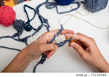 Children's hands are crocheted and thread. View from above Children's hands are crocheted and thread. View from above 75239088