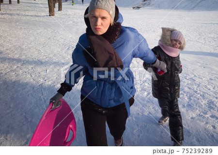 Happy family mother and baby girl daughter playing and laughing in winter outdoors in the snow. Happy family mother and baby girl daughter playing and laughing in winter outdoors in the snow. 75239289