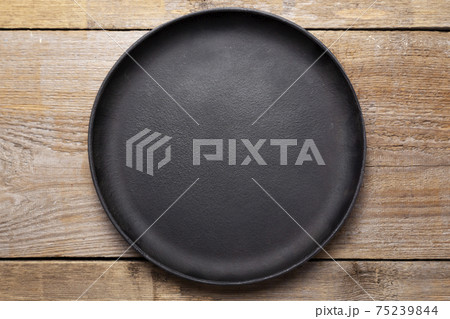 Empty cast iron frying pan on wooden culinary background. Space for text. Empty cast iron frying pan on wooden culinary background. Space for text. 75239844