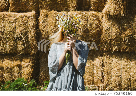 Cottagecore Farmcore Countrycore aesthetics, fresh air, countryside, slow life, pastoral life, outdoor picnics, wearing grandma clothes. Young girl in cotton dress with flowers walks on country farm 75240160