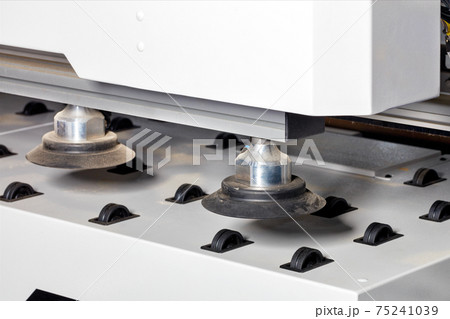 Rubber pneumatic suction cups on the chipboard feed line on a modern woodworking machine, close-up. 75241039