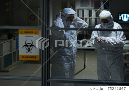 Two female clinicians in protective workwear getting ready for contacts with patients with covid19 75241867