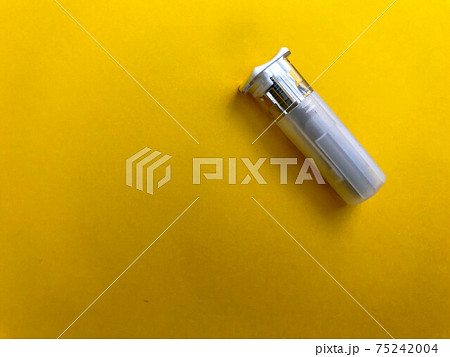 small white lancet on a yellow bright background. finger puncture. medical procedure for health. blood test, assessment of your health small white lancet on a yellow bright background. finger puncture. medical procedure for health. blood test, assessment of your health 75242004