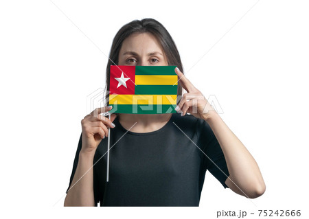 Happy young white woman holding flag Togo flag and covers her face with it isolated on a white background Happy young white woman holding flag Togo flag and covers her face with it isolated on a white background 75242666