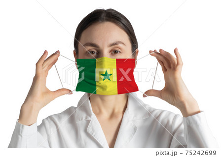 Respirator with flag of Senegal Doctor puts on medical face mask isolated on white background 75242699