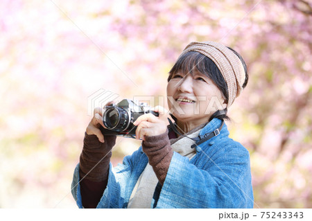 写真を撮るシニア女性 75243343