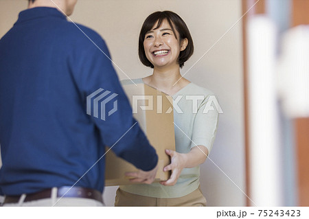 配達の荷物を受け取る女性 配達の荷物を受け取る女性 75243423