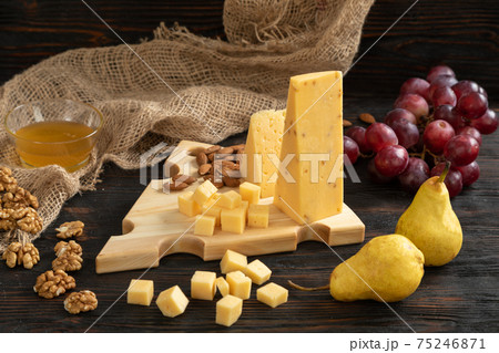 Cheese, pears and nuts on a wooden cutting board 75246871