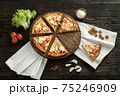 Delicious pizza on a wooden cutting board 75246909