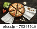 Delicious pizza on a wooden cutting board 75246910