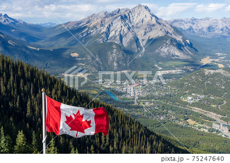 National Flag of Canada with Town of Banff in background. Cascade Mountain and surrounding Canadian Rocky Mountains in summer time. Banff National Park, Alberta, Canada. National Flag of Canada with Town of Banff in background. Cascade Mountain and surrounding Canadian Rocky Mountains in summer time. Banff National Park, Alberta, Canada. 75247640