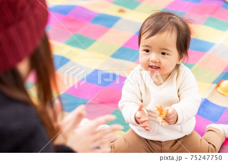 赤ちゃんをあやす女性 手を叩く の写真素材