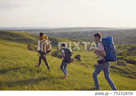 Happy trip family hikers with backpacks is walking in nature. Camping in the nature. 75252659