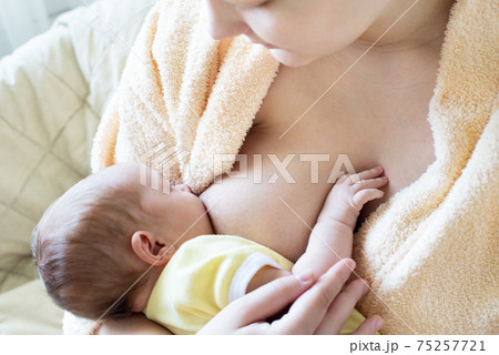 Baby eating breast milk. Caucasian blonde young mother breastfeeding her baby horizontal photo. Concept of lactation. Baby eating breast milk. Caucasian blonde young mother breastfeeding her baby horizontal photo. Concept of lactation. 75257721