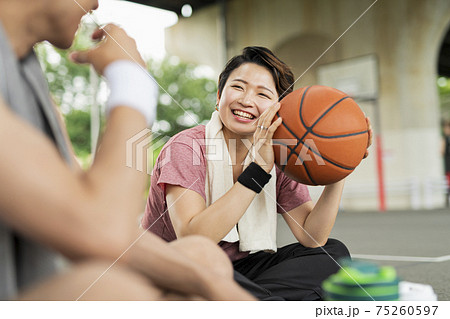 バスケの練習中に休憩をとる男女 バスケの練習中に休憩をとる男女 75260597