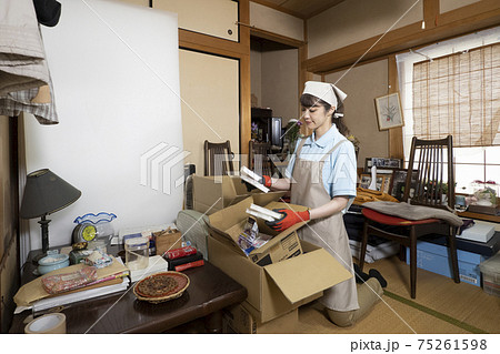 散らかった部屋を片付ける女性作業員 散らかった部屋を片付ける女性作業員 75261598