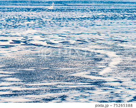 Bubbles and pieces of clear natural ice on frozen lake in evening sun. Bubbles and pieces of clear natural ice on frozen lake in evening sun. 75265388