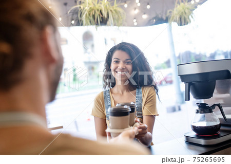 Woman picking up ordered takeaway coffee Woman picking up ordered takeaway coffee 75265695